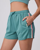 Teal athletic shorts with a brand logo on a plain background